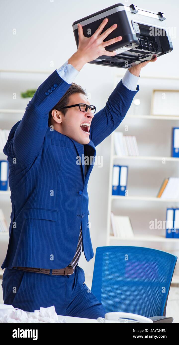 Businessman angry at copying machine jamming papers Stock Photo - Alamy