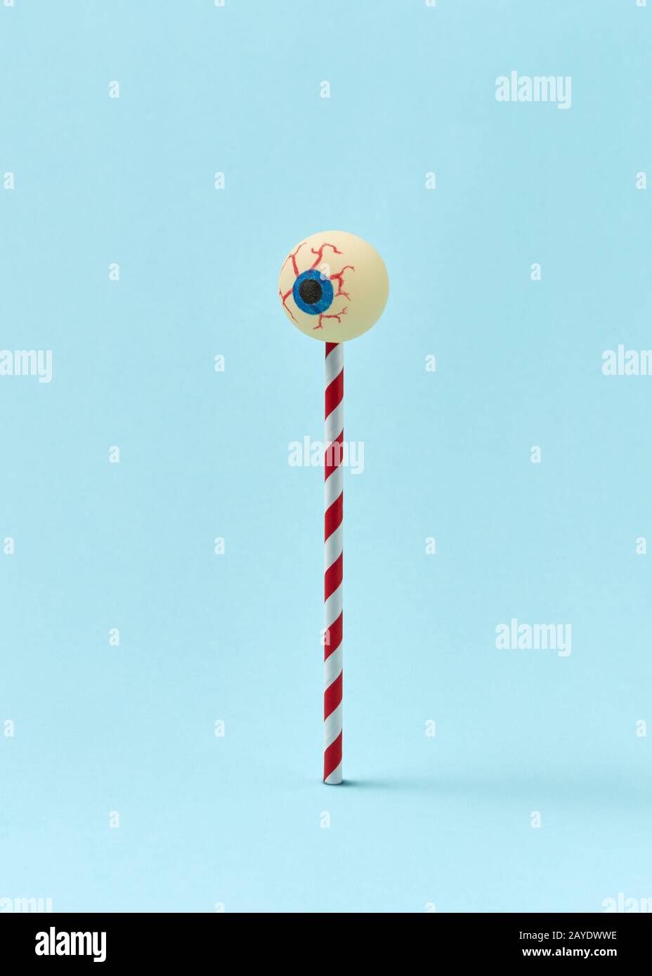 Human eyeball on a plastic straw as a candy. Stock Photo