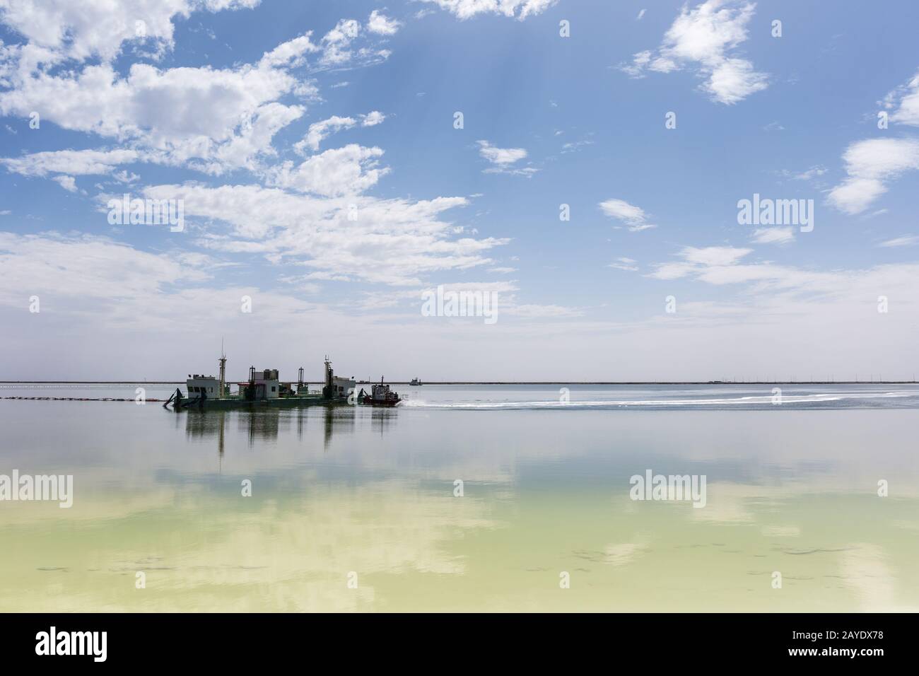 salt mining ship and blue sky reflection in qarhan salt lake Stock Photo