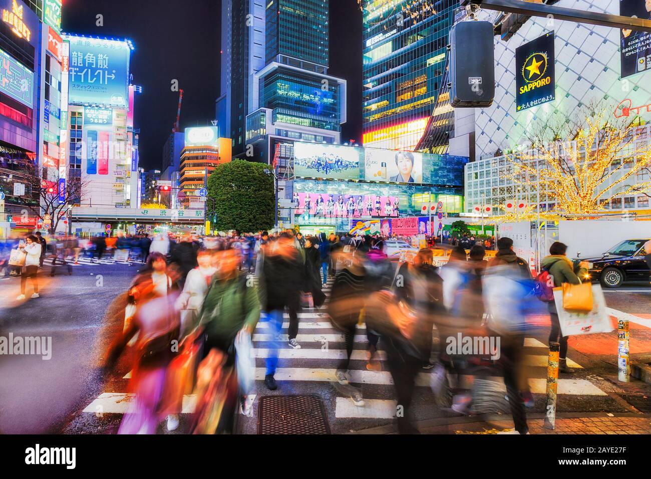 Shibuya, TOKYO, JAPAN - 29 December 2019: Famous Shibuya crossing in TOkyo city at night with blurred people crowds and bright billboards. Stock Photo