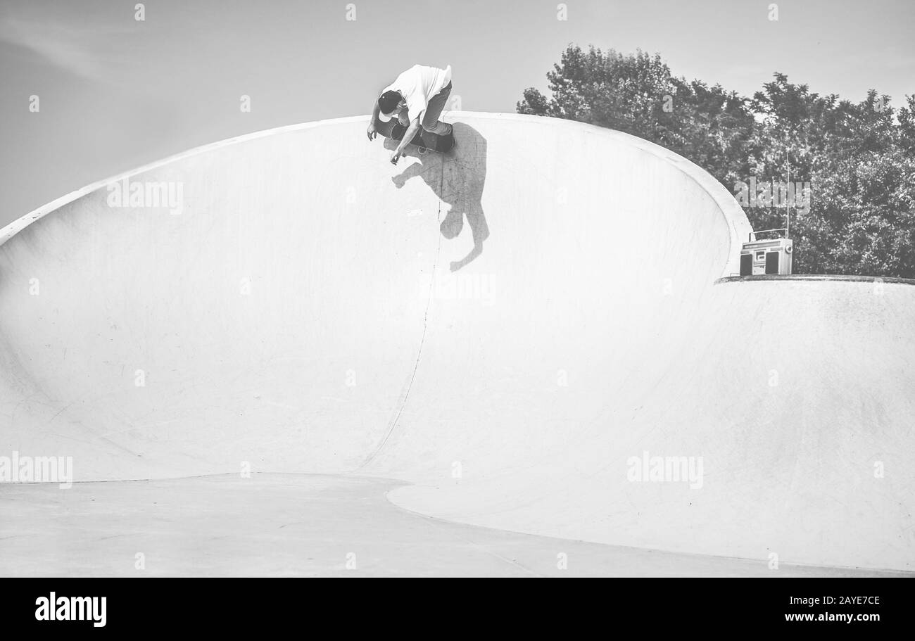 Skater performing in skate park ramp - Young man riding skateboard in ...