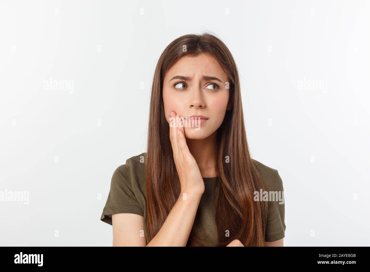 Teen woman pressing her bruised cheek with a painful expression as if she is having a terrible tooth ache Stock Photo