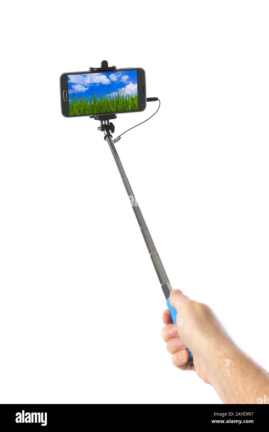 Hand with smartphone selfie stick and landscape (my photo) Stock Photo
