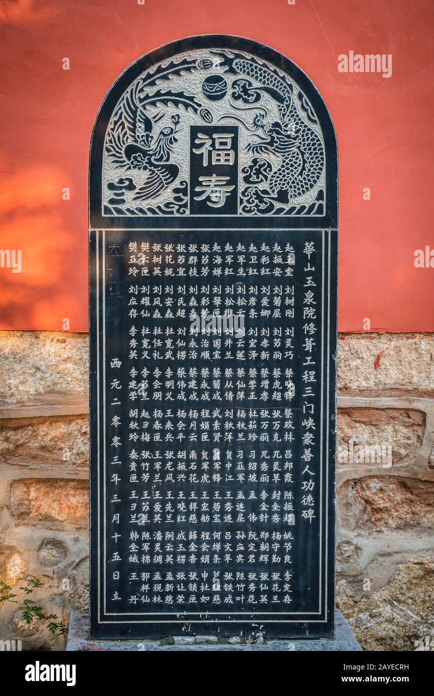 Chinese graphic engraved writing and images on a temple  wall Stock Photo