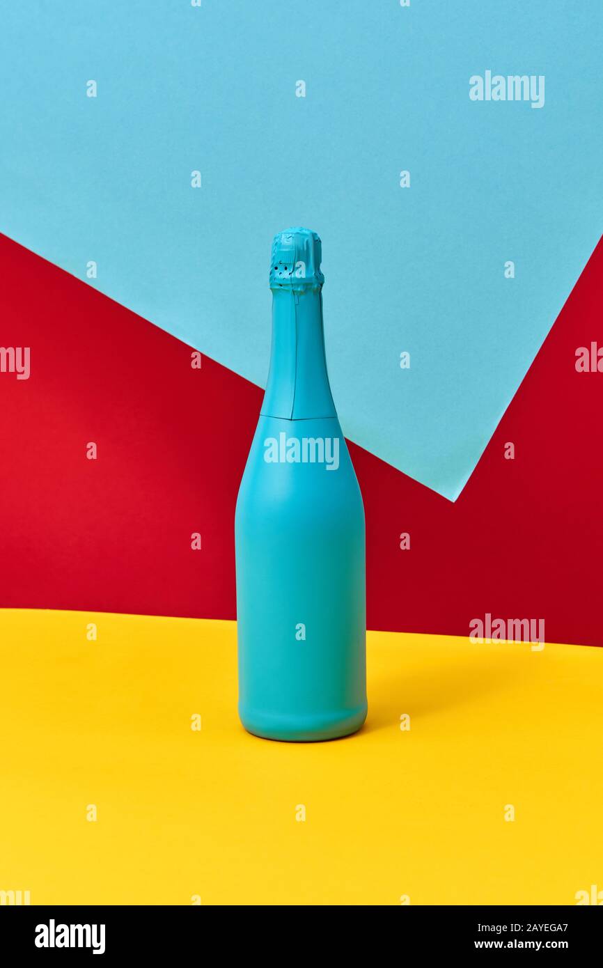 Decorative painted blue champagne bottle on a tricolor background Stock