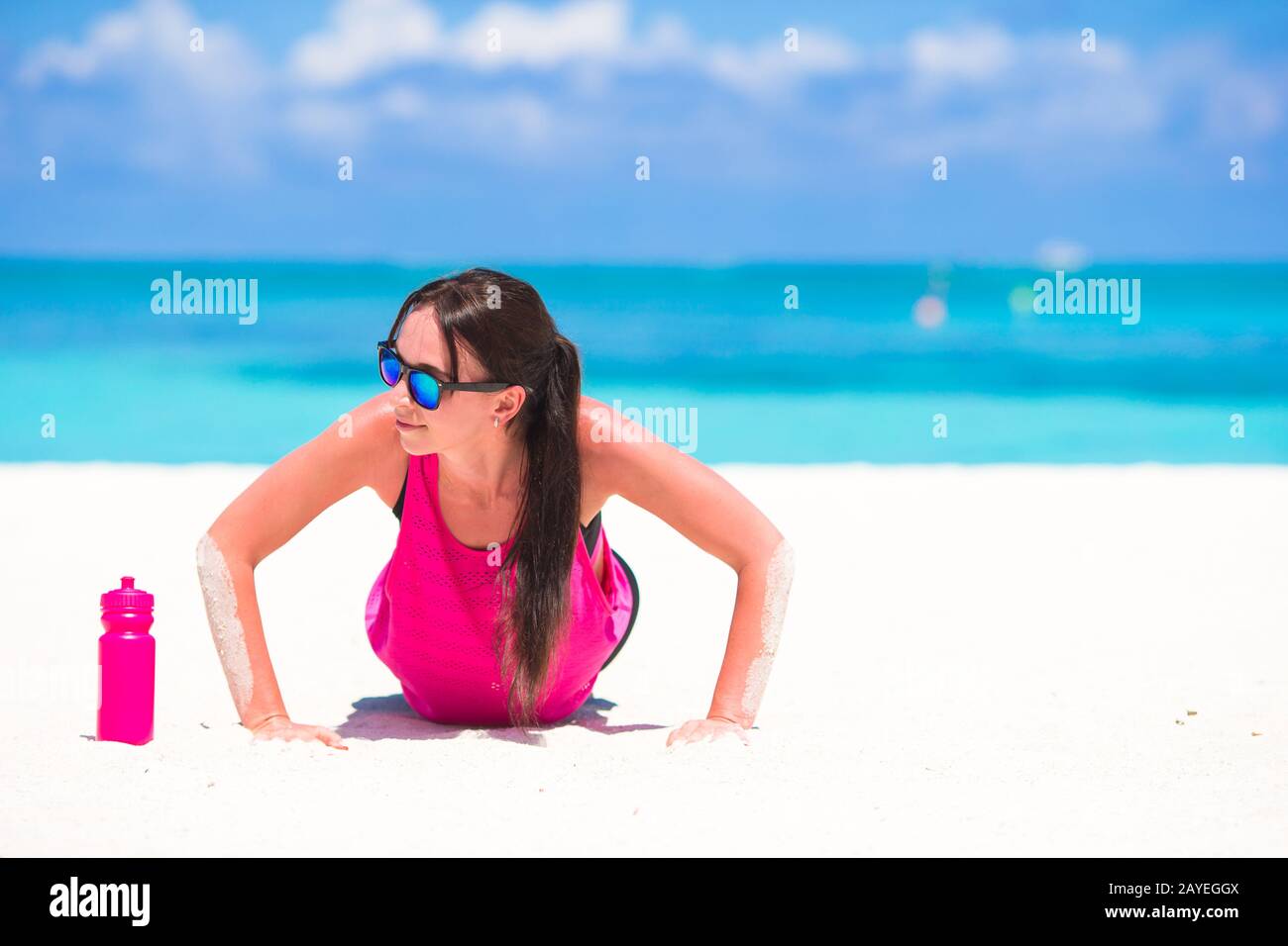 Fit young woman on tropical white beach in her sportswear Stock Photo