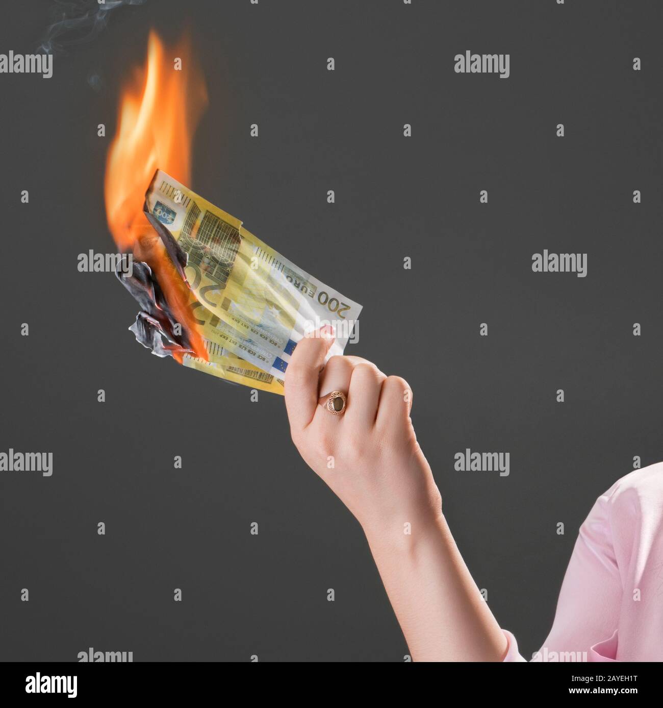 Smiling girl burns money. Concept of extravagance Stock Photo