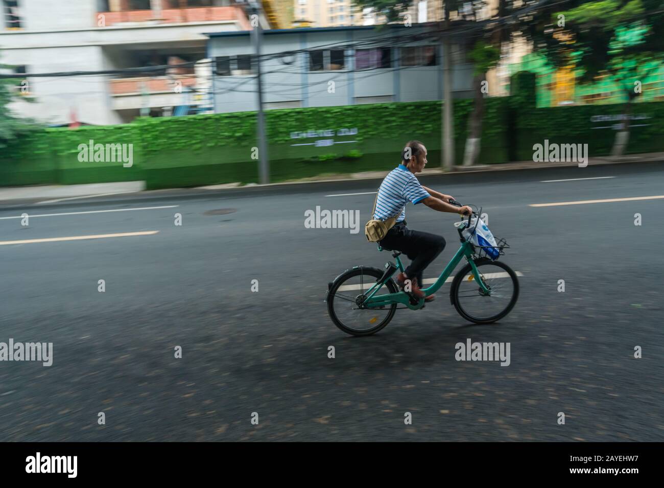 Chinese man riding on a bicycle in Chengdu Stock Photo