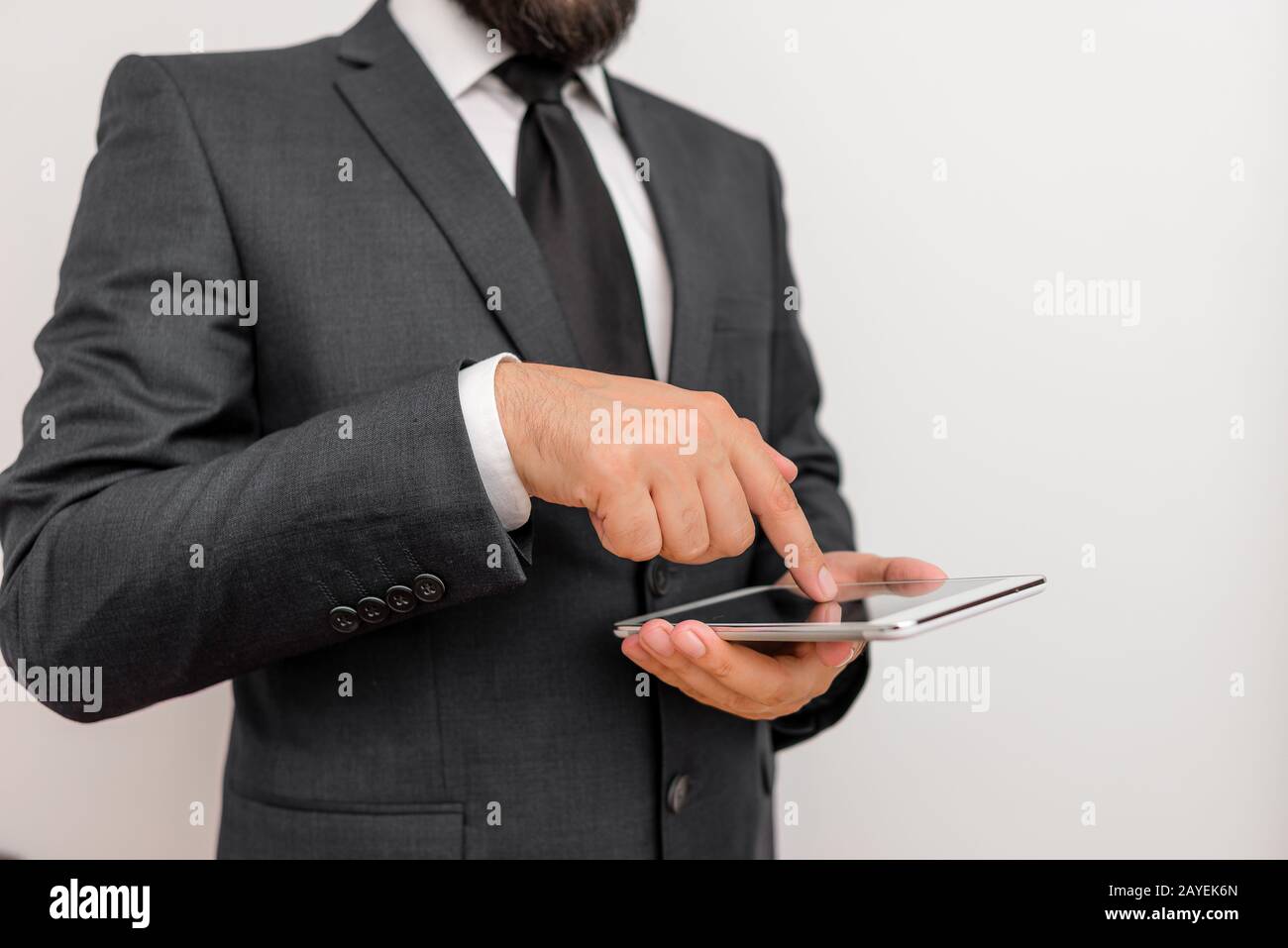 Male human wear formal working clothes presenting presentation of high technology smartphone device. Man dressed in work suit pl Stock Photo