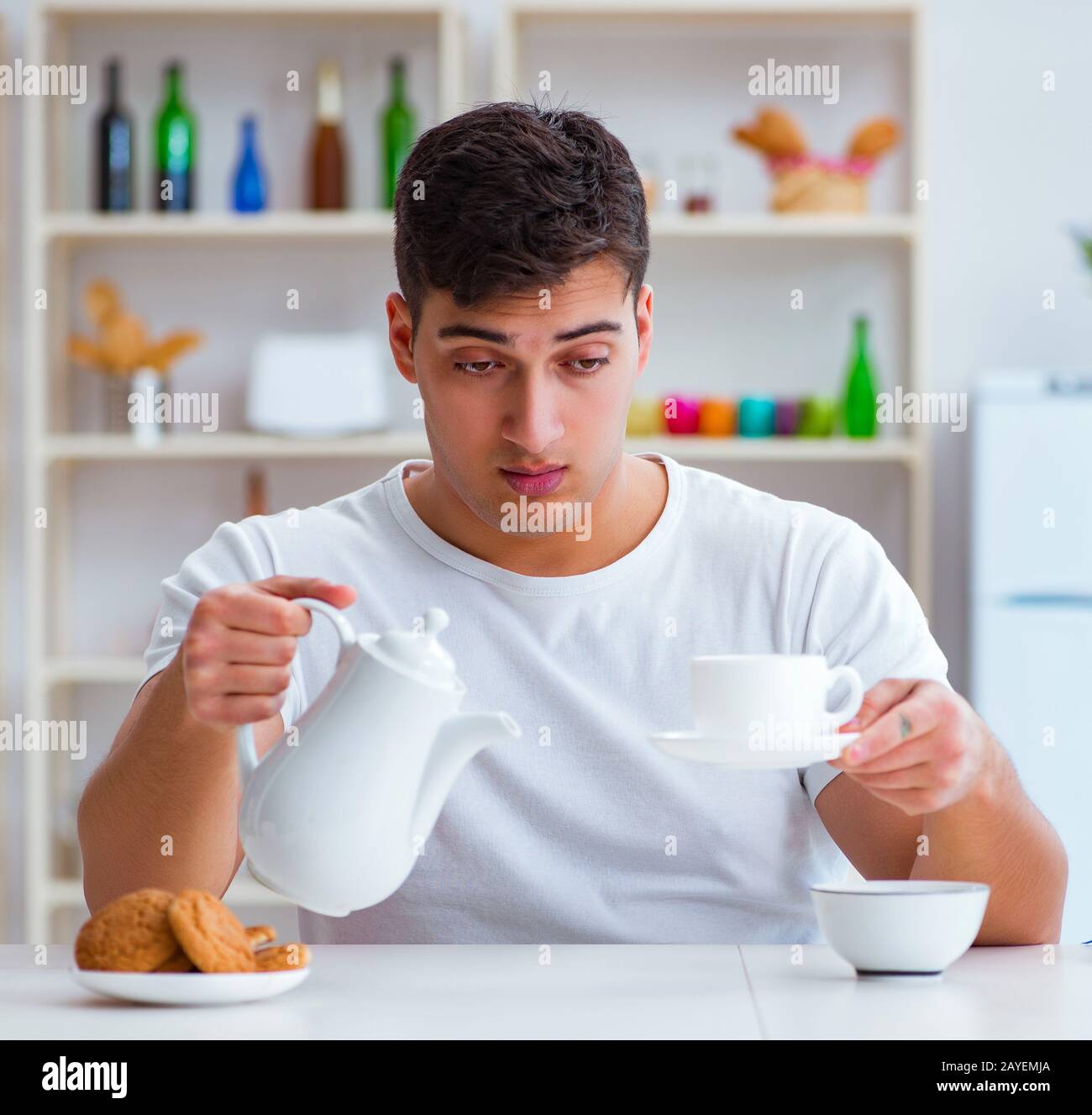 Man falling asleep during his breakfast after overtime work Stock Photo