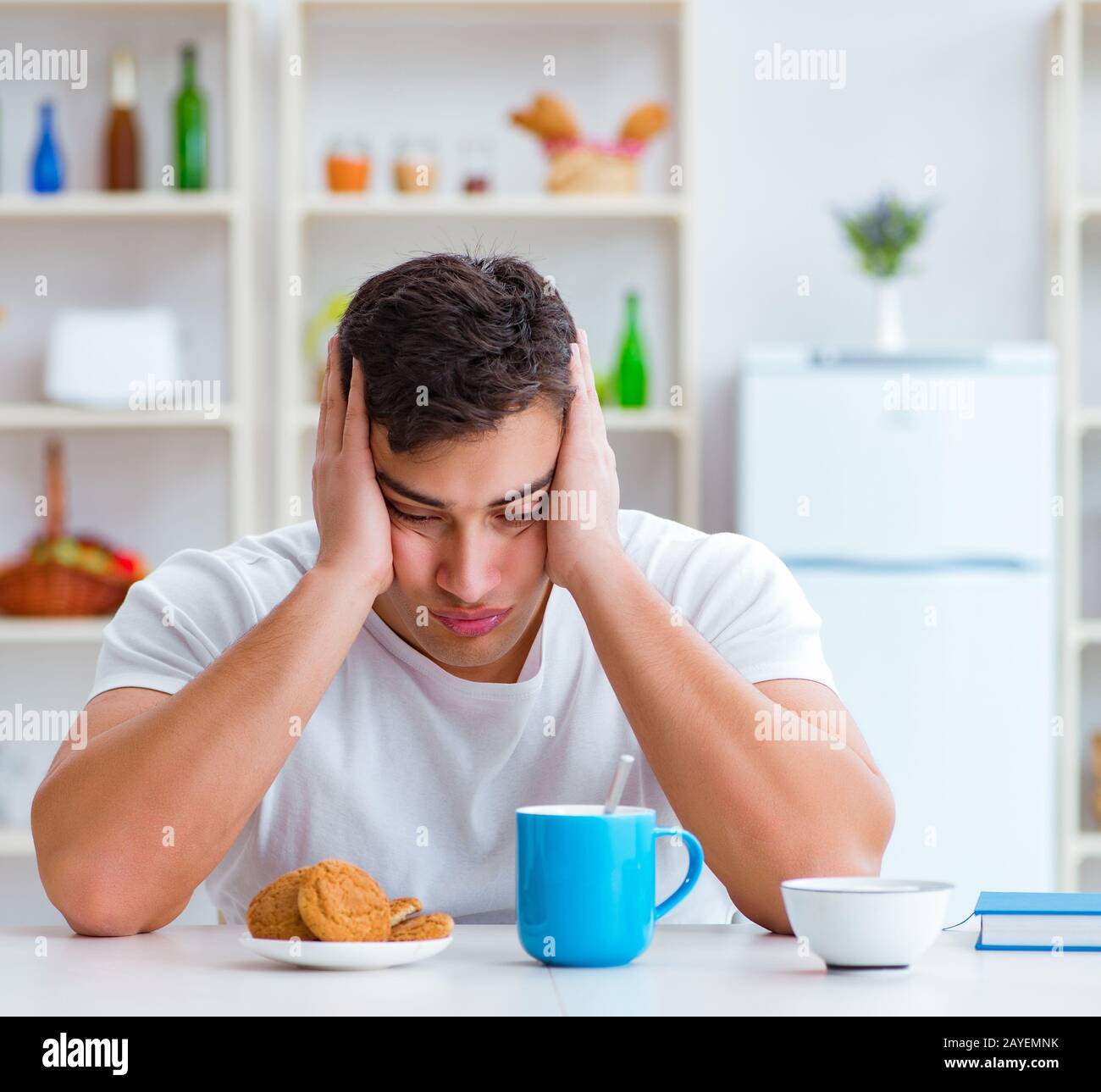 Man falling asleep during his breakfast after overtime work Stock Photo