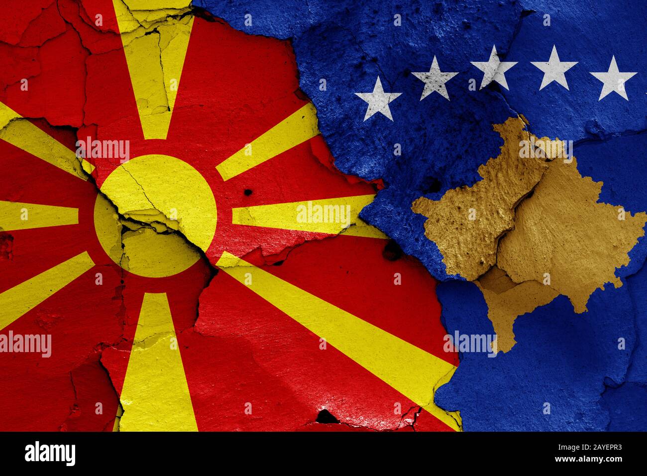 flags of North Macedonia and Kosovo painted on cracked wall Stock Photo