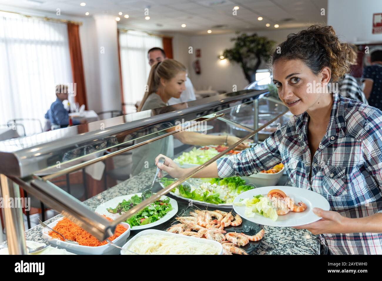 Stock photo of two girls picking up food at a selfservice restaurant
