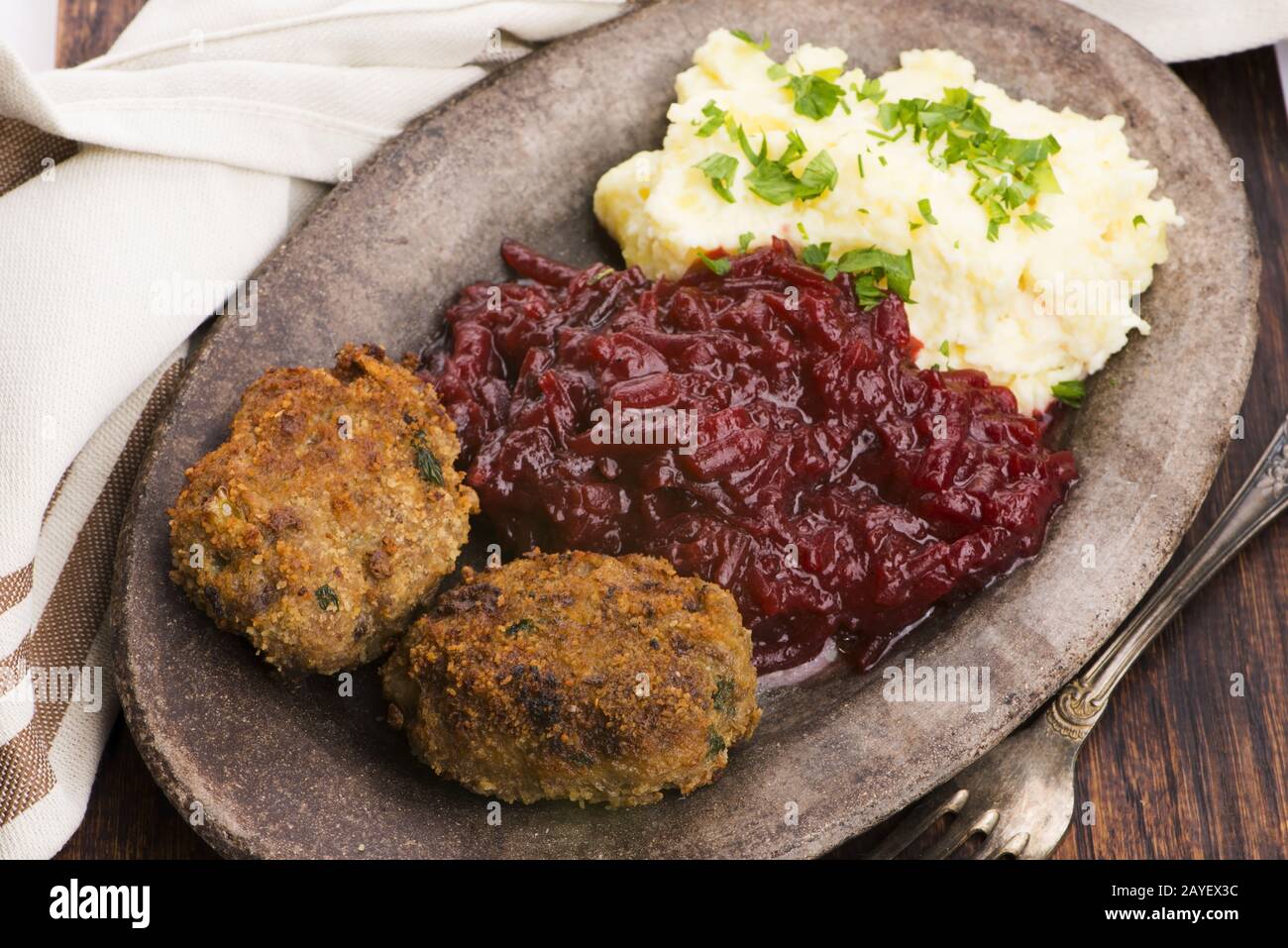 Prepared dinner on the plate. Melted meat, potatoes, beetroot Stock Photo