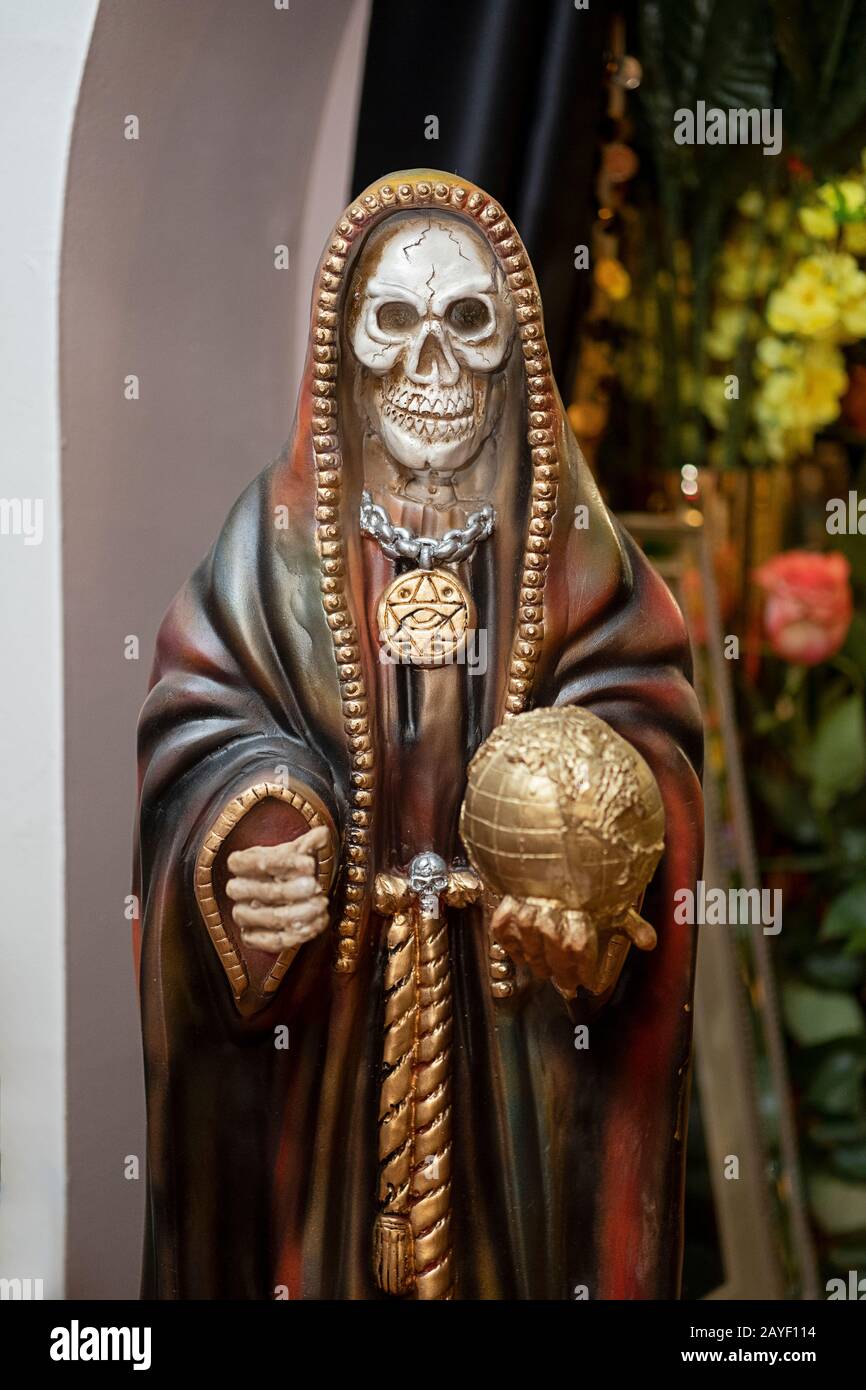 A Santa Muerte statue holding a globe displayed in a home temple in Jackson Heights, Queens, New York City. Stock Photo