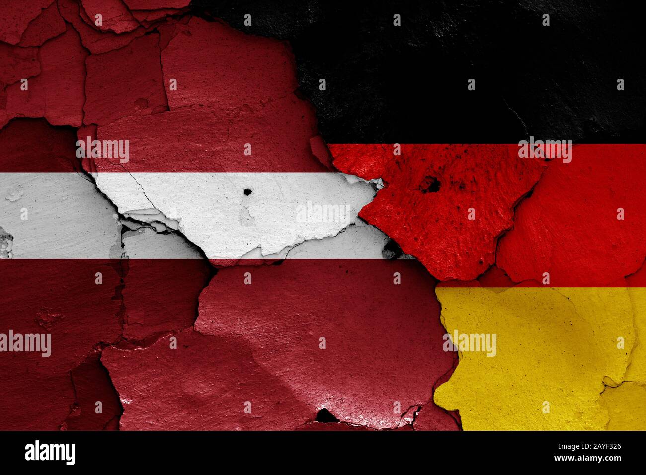 flags of Latvia and Germany painted on cracked wall Stock Photo