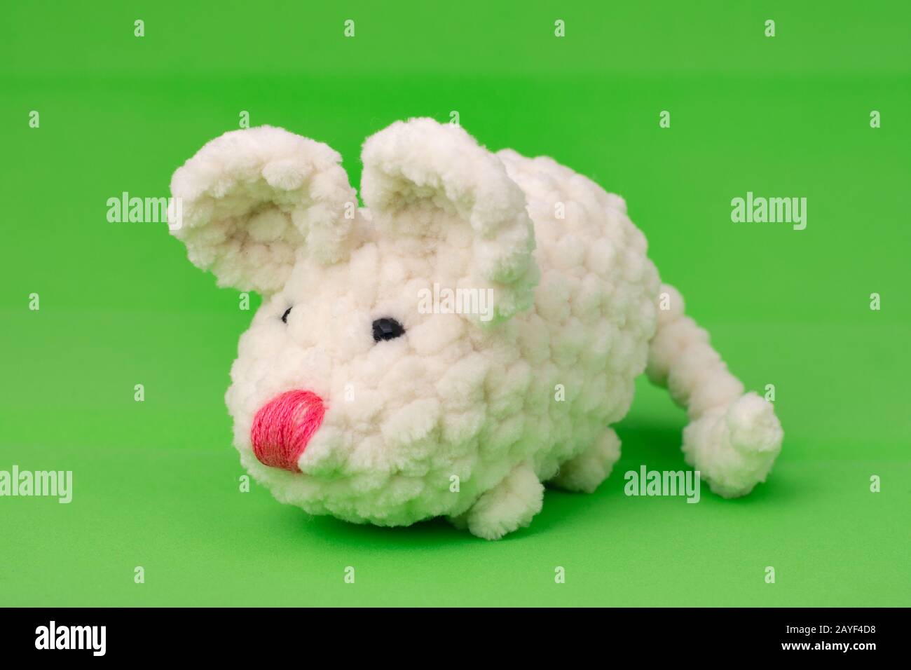 White knitted mouse, made with its own hands, on a green background Stock Photo