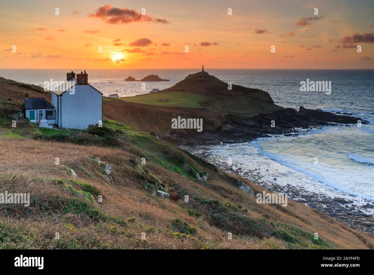 The setting sun captured form the South West Coast Path with Cape Cornwall and The Brisons in the distance. Stock Photo