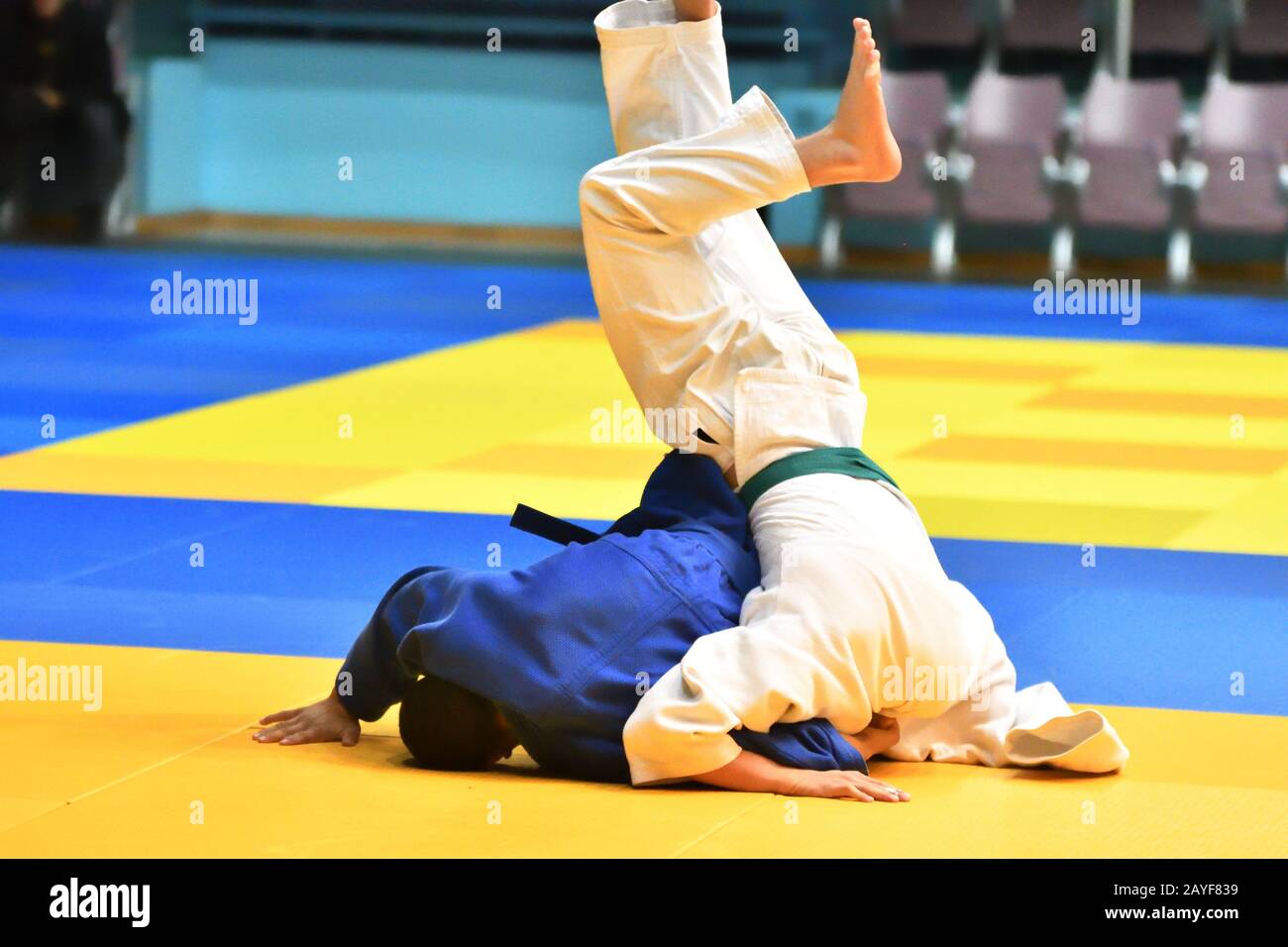 Two judoka in kimono compete on the tatami Stock Photo