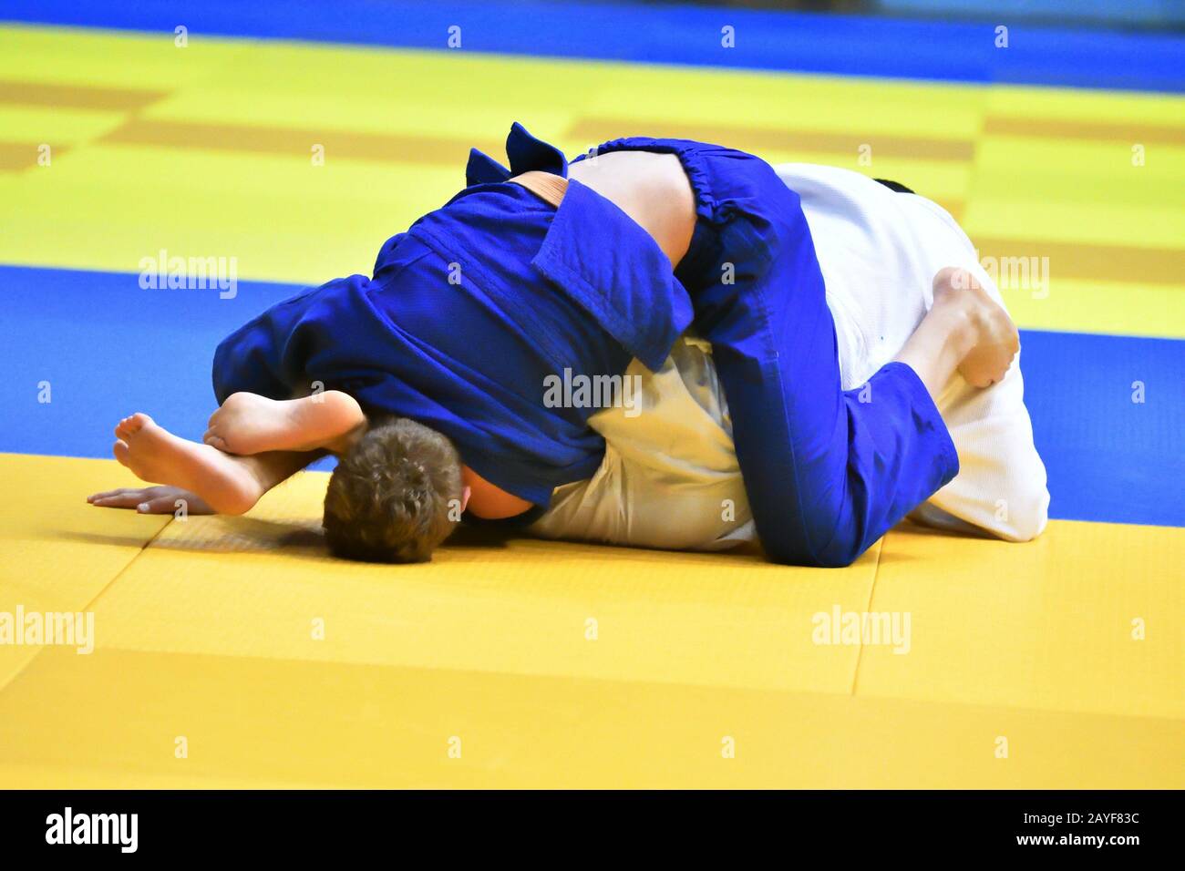 Two judoka in kimono compete on the tatami Stock Photo
