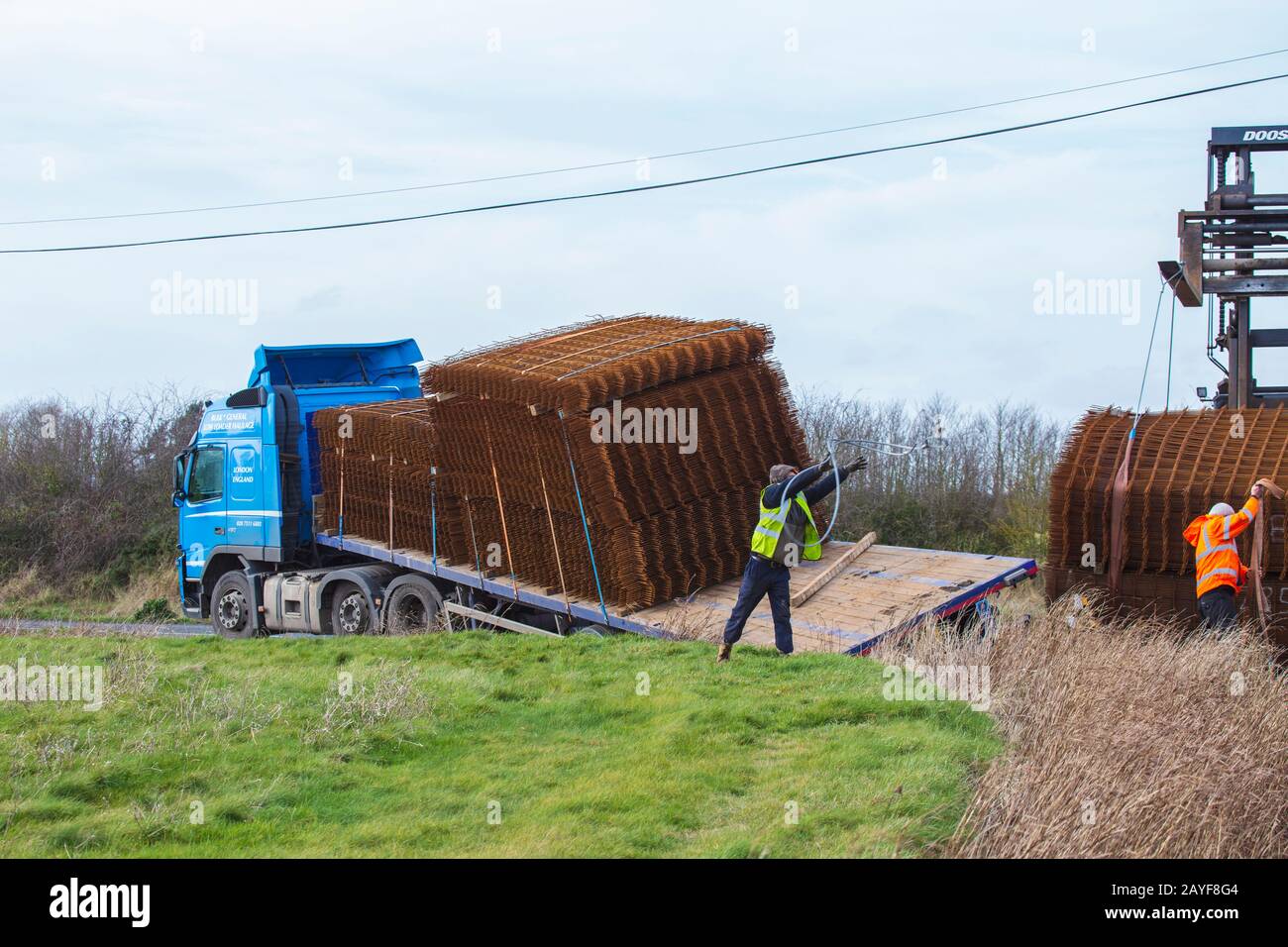 People at Scene of HGV Accident-Rear Wheels Slide in to Ditch on Sharp Bend. HGV Heavily Laden with Steel for Reinforcing Concrete Stock Photo