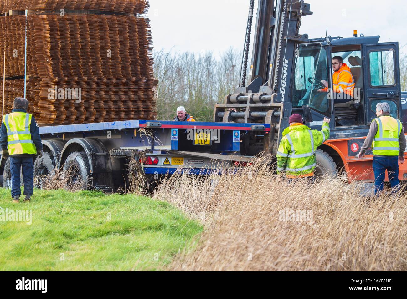 People at Scene of HGV Accident-Rear Wheels Slide in to Ditch on Sharp Bend. HGV Heavily Laden with Steel for Reinforcing Concrete. Stock Photo