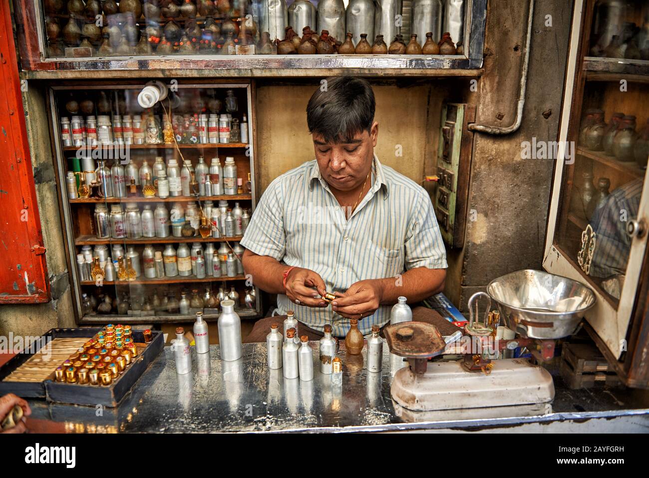 man in Perfume shop mixing fragrances, colorful streetlife  on market of Jodhpur, Rajasthan, India Stock Photo