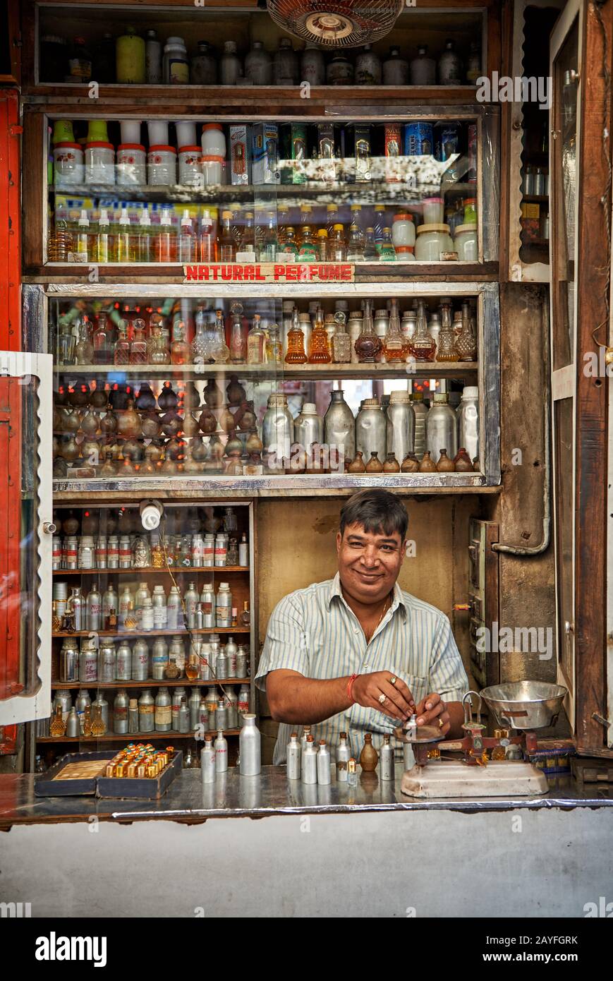 man in Perfume shop mixing fragrances, colorful streetlife  on market of Jodhpur, Rajasthan, India Stock Photo