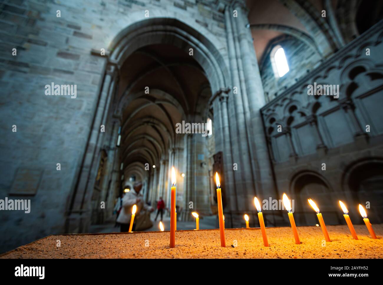 Architecture of beautiful old church in Germany. Candles in foreground and arches in background Stock Photo