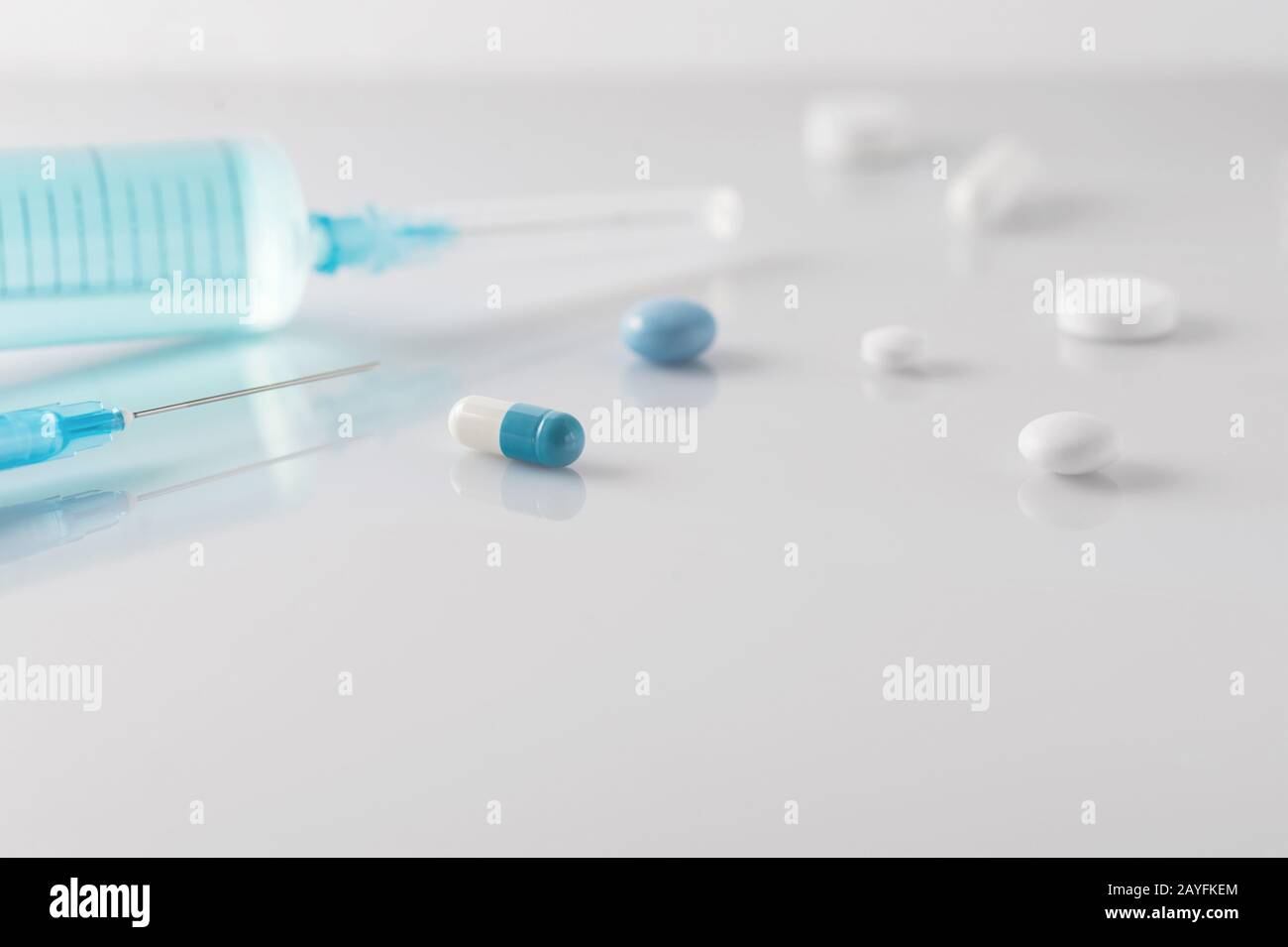 Medical capsule, pills and medical syringes on light  background with copy space, medical and healthcare concept. Selective focus, horizontal Stock Photo