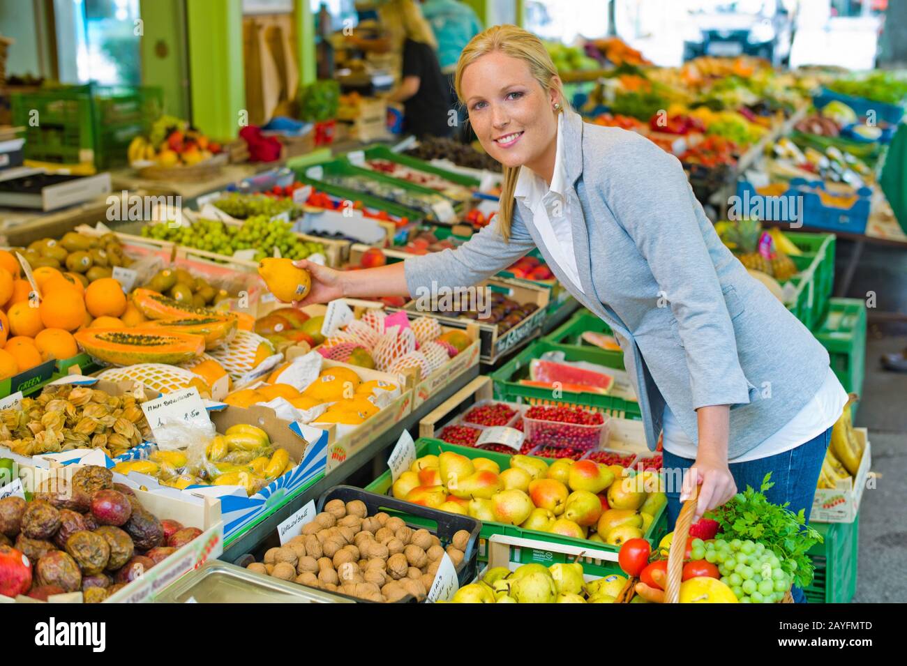 Eine junge Frau kauft Obst und Gemuese auf einem Wochenmarkt. Frische und gesunde Ernaehrung. Stock Photo