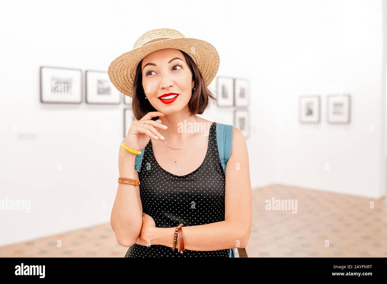 Pensive Woman esthete intellectual looking at paintings or photos in the gallery of fine art Stock Photo