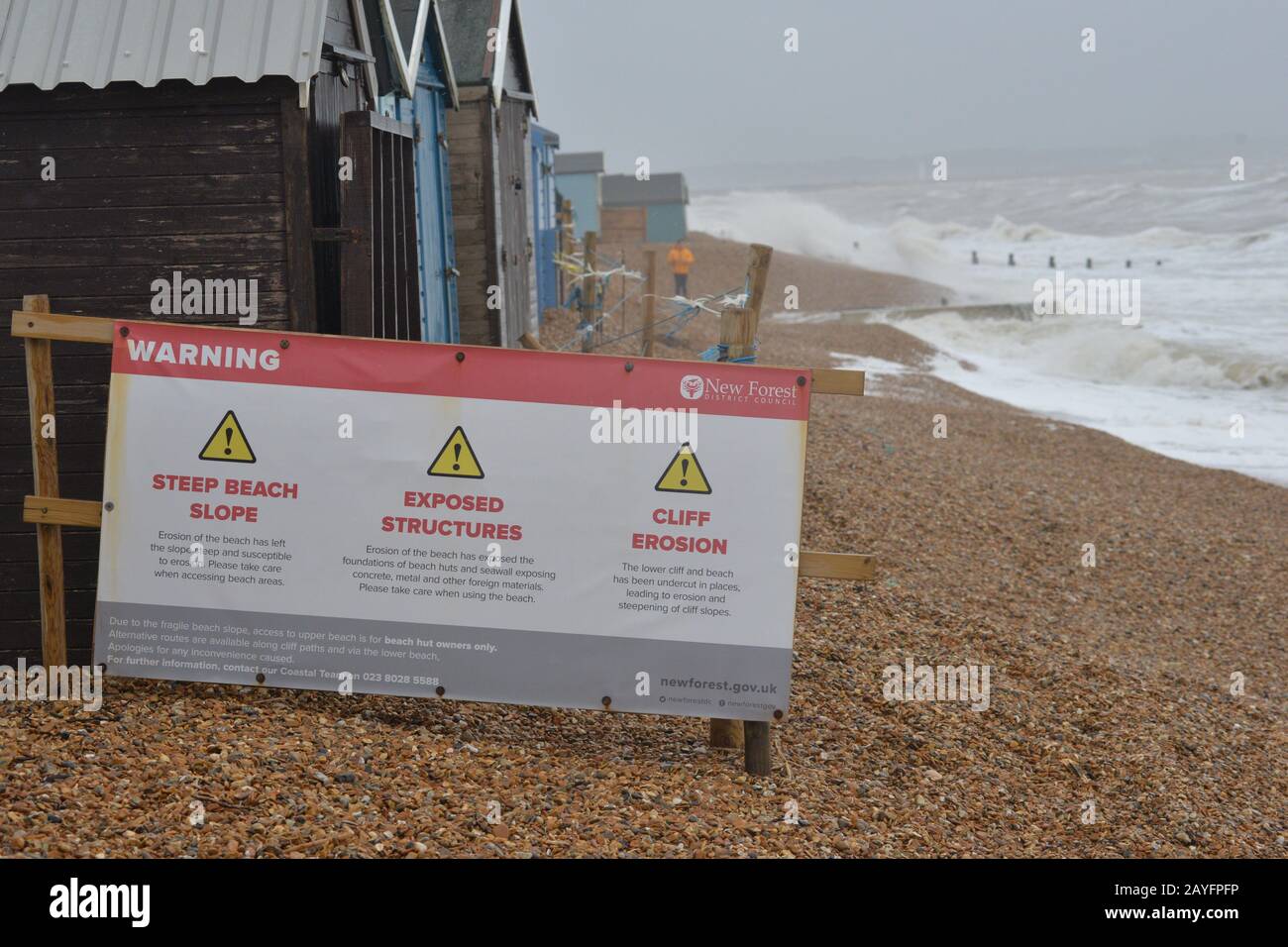 Storm Dennis, classified as a bomb cyclone, brings gale force winds and heavy rain to the south coast. The strong wind whips up the sea into huge waves. Warning signs on the beach, Milford-on-Sea, Hampshire, England, UK, 15th February 2020, Weather: Stock Photo