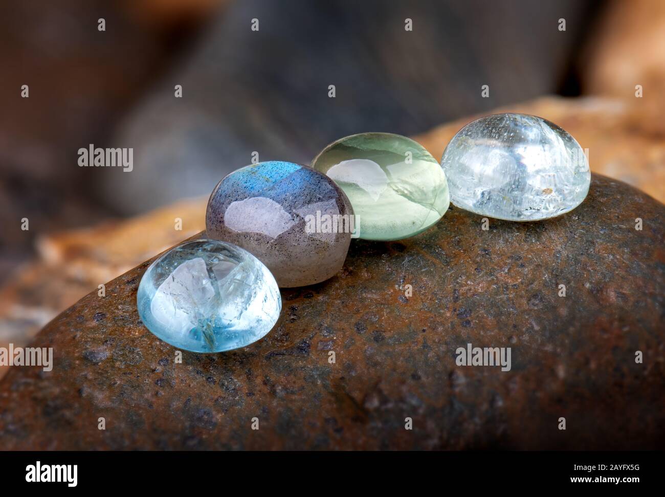 Round cut quartz and emerald mineral gemstones with stone background. Stock Photo