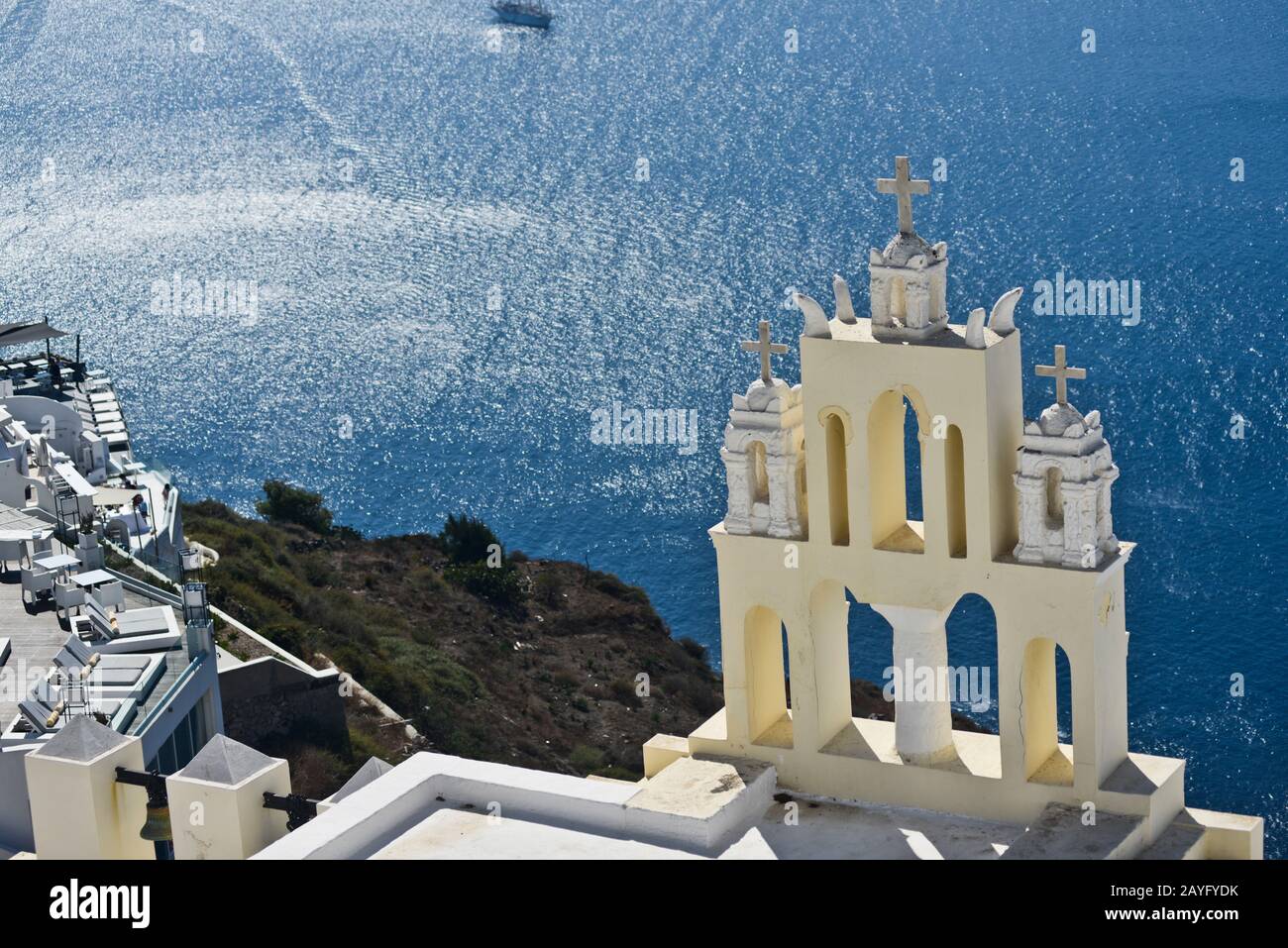 Yellow church bell tower on the edge of the town of Fira on Santorini island, Greece. Stock Photo