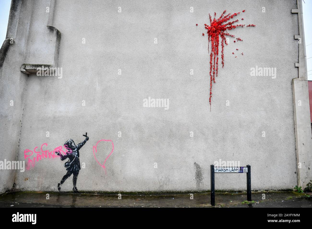 NOTE IMAGE CONTAINS SWEAR WORD A Banksy work of art on the side of a house on Marsh Lane, Barton Hill, Bristol, which has been vandalised with pink spray paint, the day after it was confirmed on Valentine's Day. Stock Photo