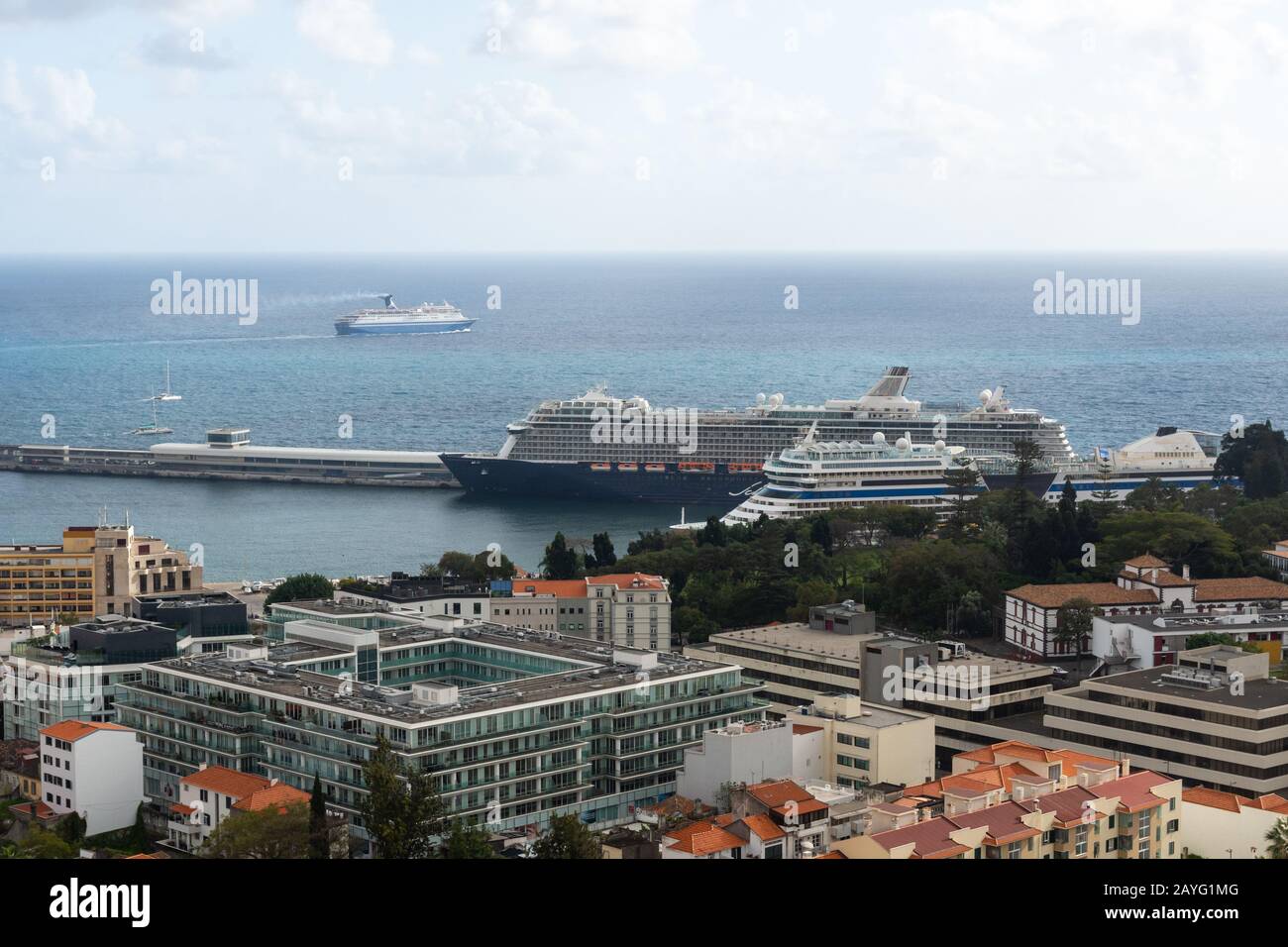 View over part of Funchal city and the harbor with two big cruise ship and a third one passing by on the sea, picture from Funchal Madeira Portugal. Stock Photo