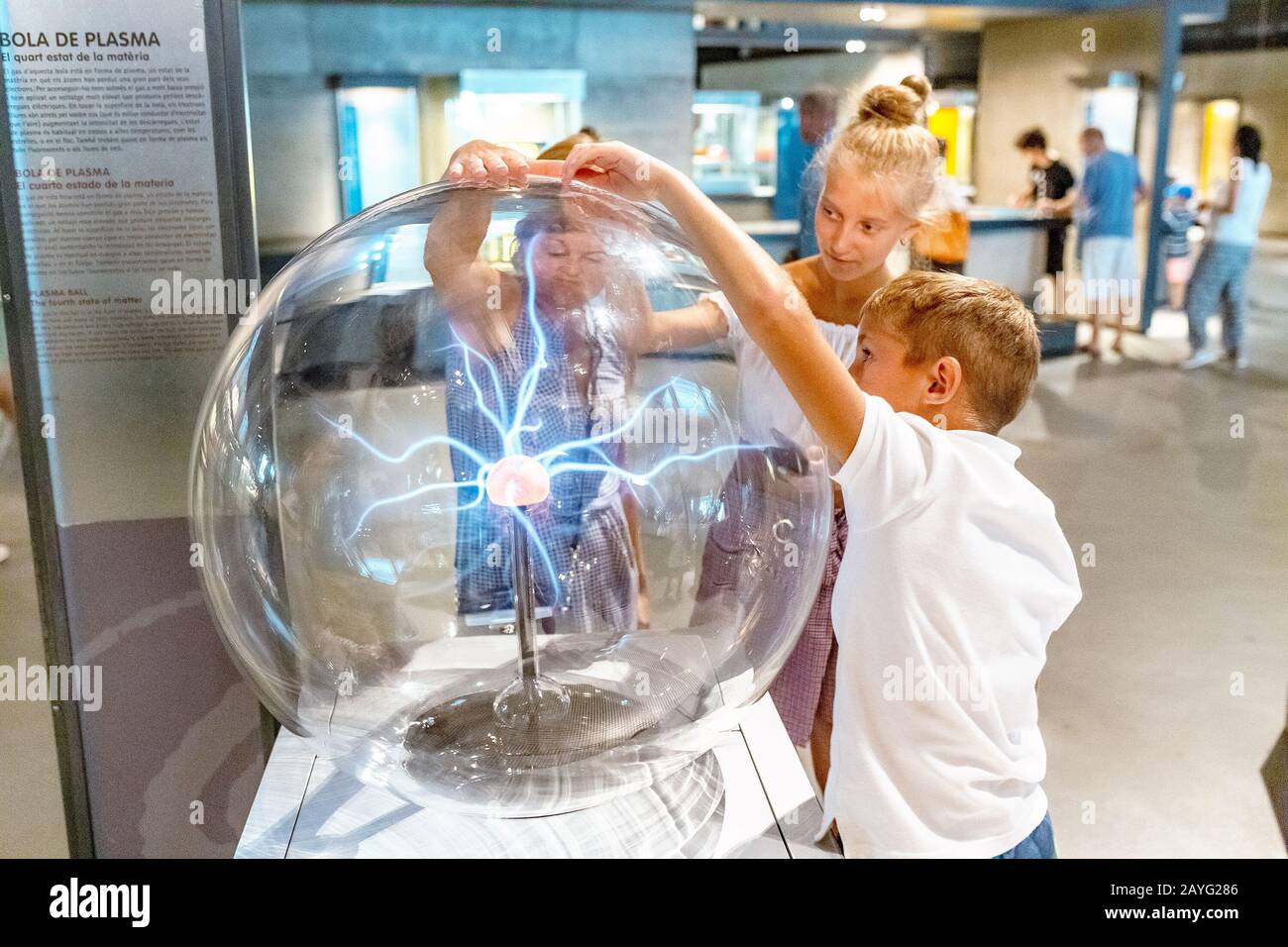 28 JULY 2018, BARCELONA, SPAIN: People playing with Plasma Ball in science museum Stock Photo