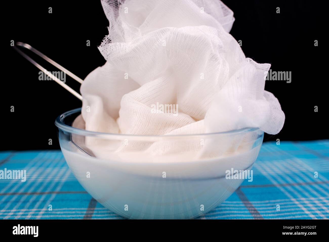 Preparing vegan almond milk at home. Pouring the milk into a cheese