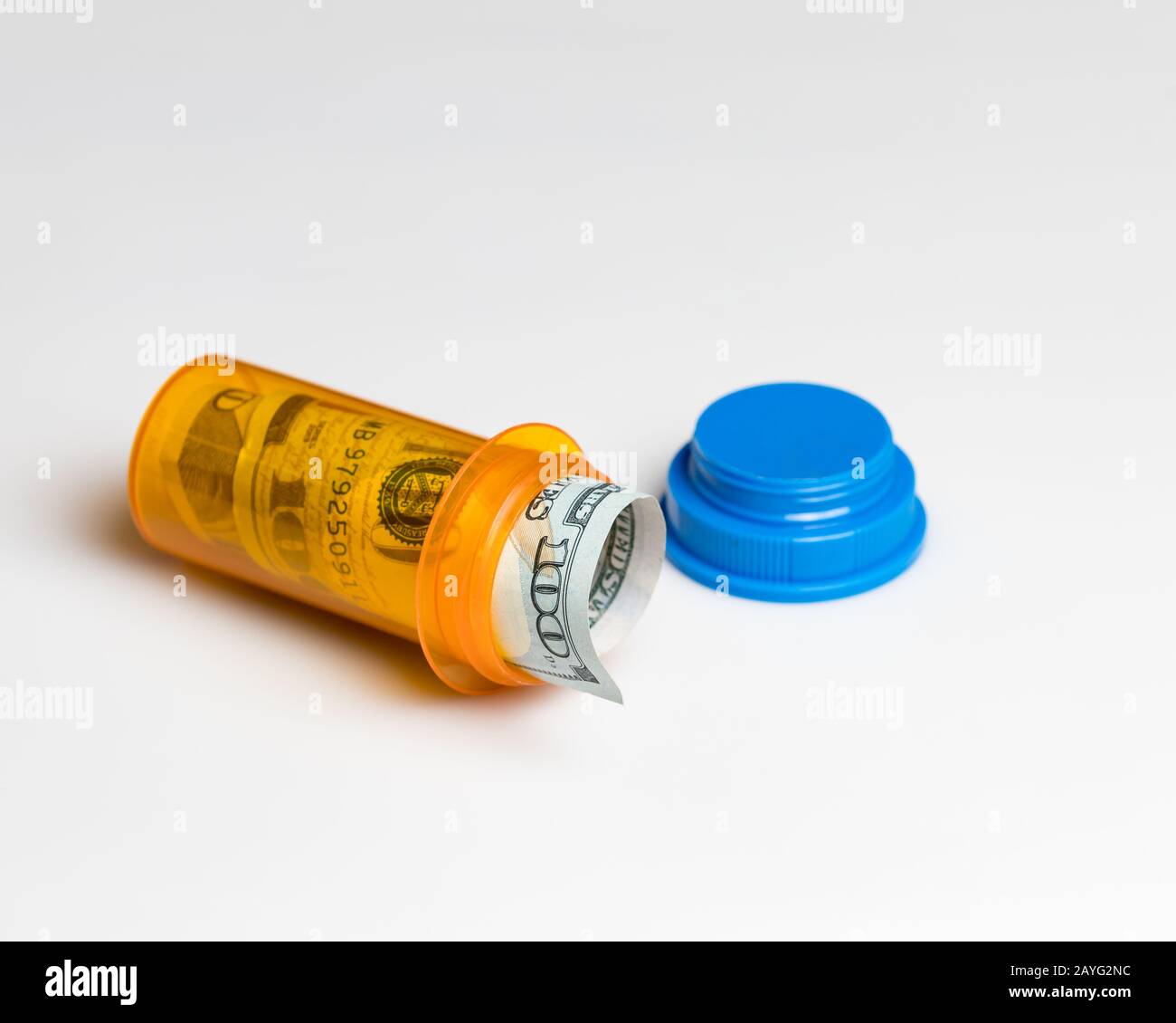 Prescription drug medicine pill bottle with 100 dollar bill inside. Concept of drug, health care, medical insurance cost Stock Photo