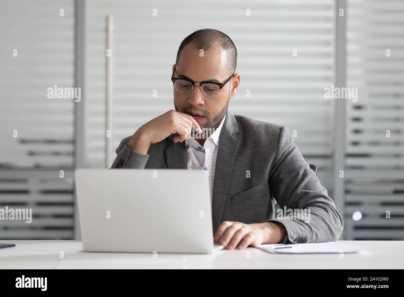 Pensive male employee look at laptop think analyzing problem Stock Photo