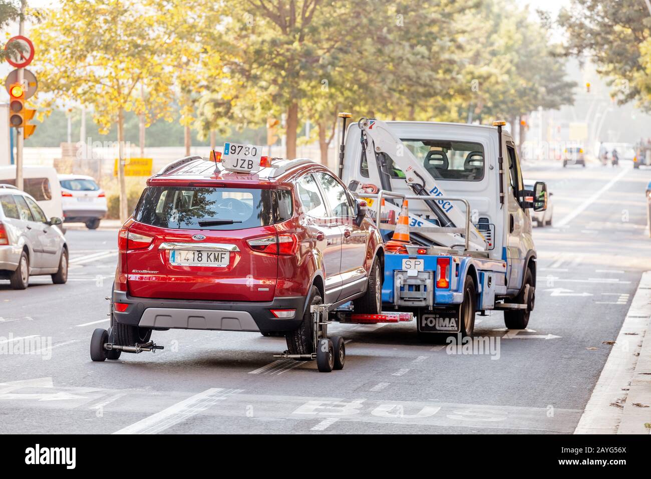 29 JULY 2018, BARCELONA, SPAIN: tow truck transporting car as punishment for wrong parking Stock Photo