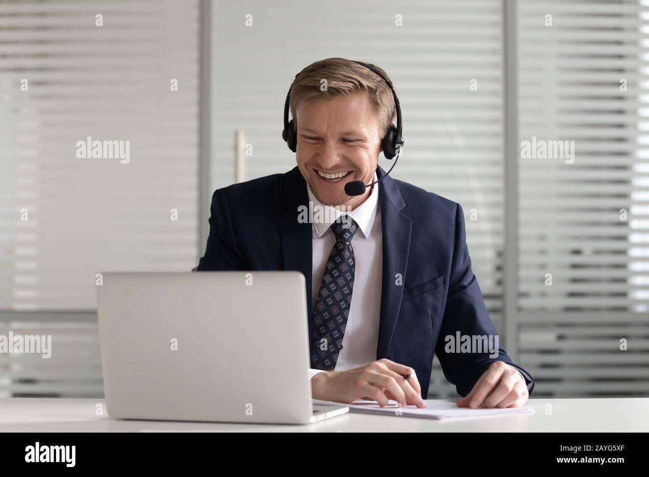 Smiling male employee make notes having video call with client Stock Photo