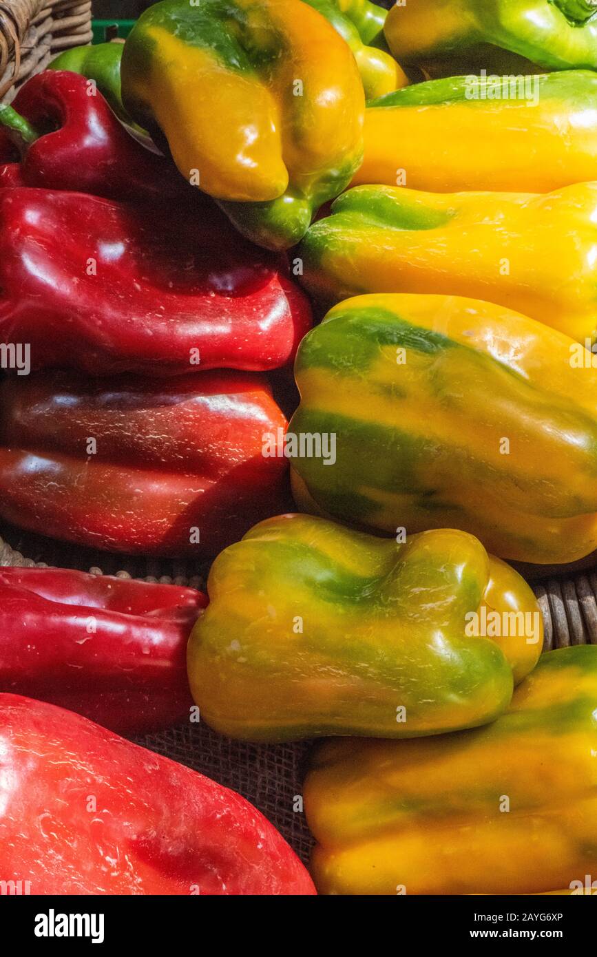 red and yellow chilli peppers on display at a market stall selling ...