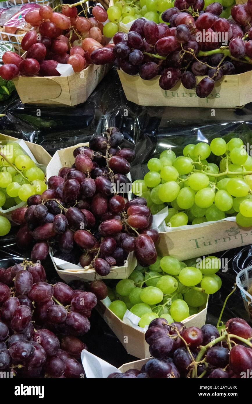 a selection of red and green grapes on sale and displayed at a fruit