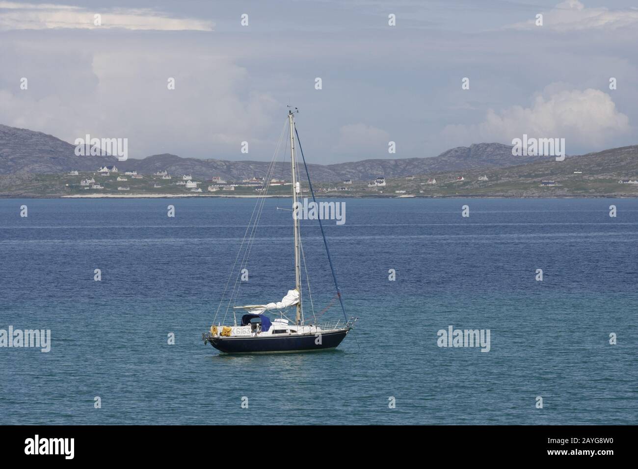 Sailing yacht anchored in the Sound of Barra, looking towards Eriskay, Western Isles, Scotland Stock Photo