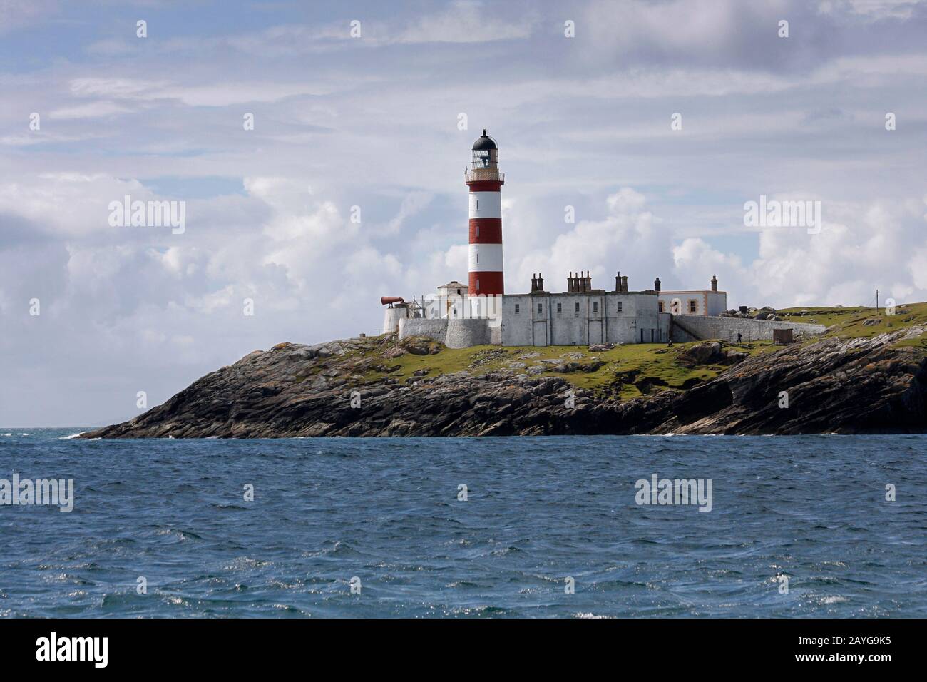 The tall, red and white striped Eilean Glas lighthouse, Scalpay, from the sea, Western Isles, Scotland Stock Photo