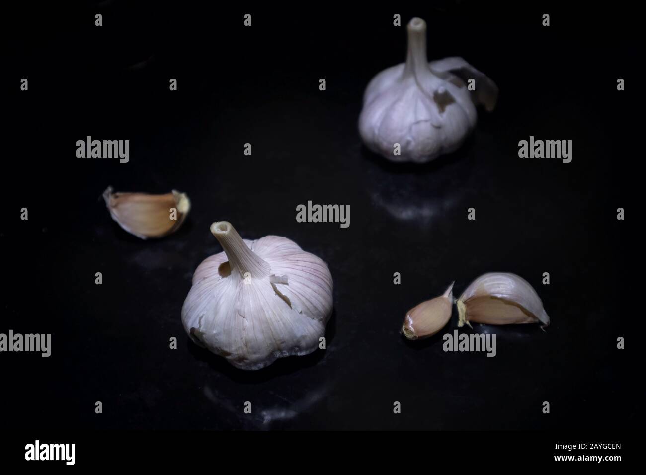 Garlic close-up product show on black background. Spice garlic clove vitamin food winter health eating Stock Photo