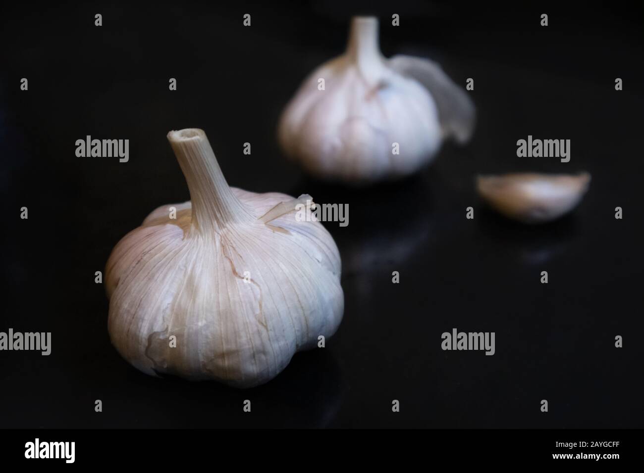 Garlic close-up product show on black background. Spice garlic clove vitamin food winter health eating Stock Photo