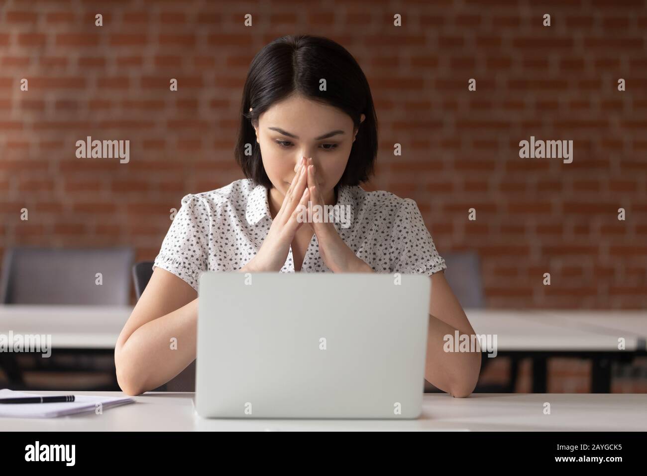 Pensive female employee look at laptop screen thinking Stock Photo - Alamy